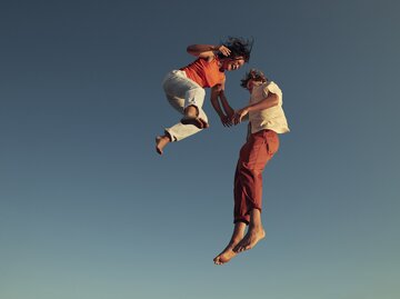 Freunde hüpfen vor Freude in die Luft | © GettyImages/Klaus Vedfelt