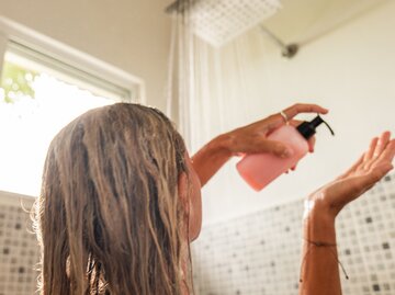 Frau wäscht ihre Haare unter Dusche | © GettyImages/Mystockimages