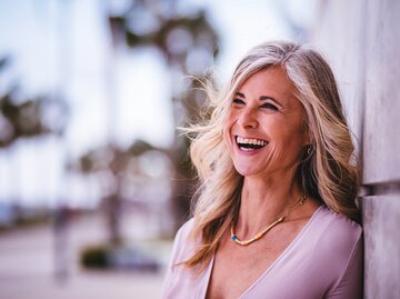 Reife Frau mit grauen Haaren, die glücklich lacht | © GettyImages/	wundervisuals