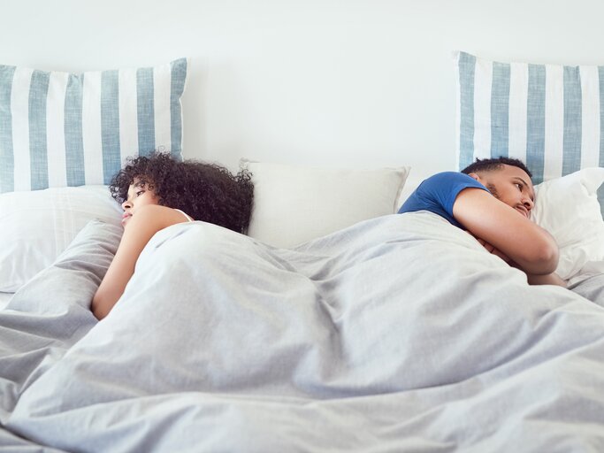 Paar liegt zerstritten im Bett | © Getty Images/	LaylaBird