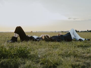 Zwei Freundinnen liegen glücklich im Gras | © Getty Images/Maskot