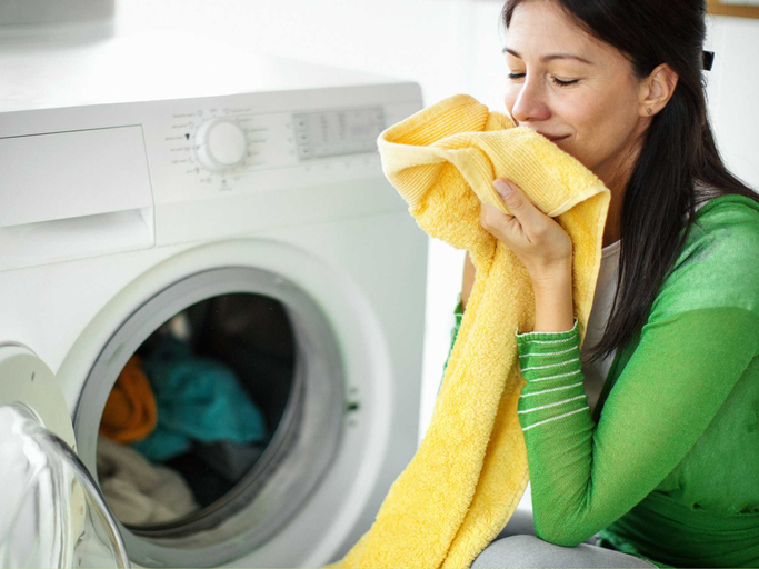 Frau riecht an frischer Wäsche | © Getty Images/gilaxia