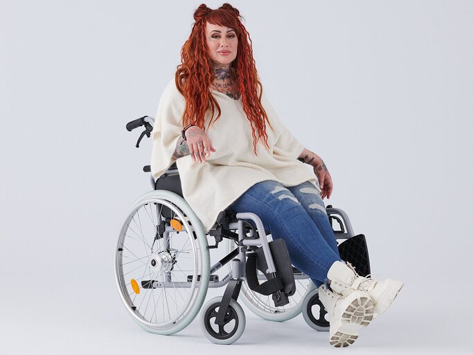 Myriam von M sitzt im Rollstuhl und schaut ernst in die Kamera. | © ENTSCHIEDEN. Gegen Krebs.
