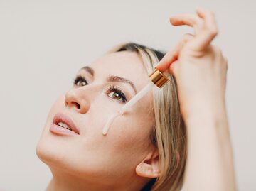 Eine Frau trägt sich ein Bakuchiol Serum auf | © GettyImages/primipil