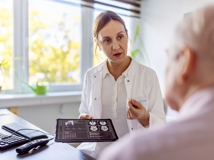 Eine Ärztin spricht mit einem Patienten, der vielleicht eine Wortfindungsstörung hat. | © GettyImages/Luis Alvarez
