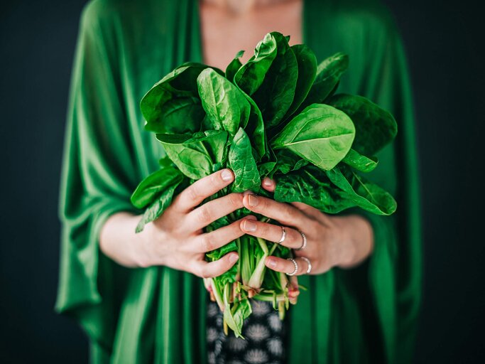 Frau hält grünes Blattgemüse in den Händen | © iStock | knape